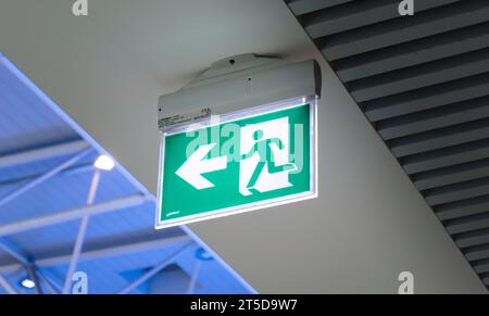 Emergency exit sign in an airport. Public safety, evacuation concept. Stock Photo