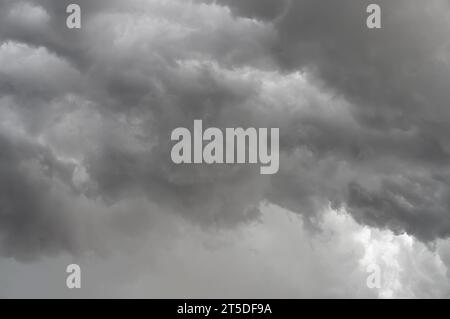 Dark, brooding storm clouds loom overhead, poised to release their downpour. Stock Photo