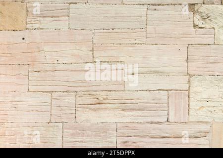Ancient sandstone stone wall on the exterior of a building in UK. Full frame pattern or texture of wall made of sandstone blocks Stock Photo