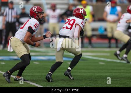 Harvard Crimson quarterback Jaden Craig #10 hands off ball to running back Shane McLaughlin #29 during action in the NCAA football game against the Columbia Lions at Robert K. Kraft Field at Lawrence A. Wien Stadium in New York, New York, Saturday, Nov. 4, 2023. (Photo: Gordon Donovan) Stock Photo