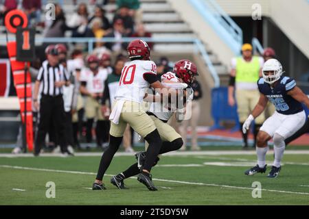 Harvard Crimson quarterback Jaden Craig #10 hands off ball to running back Shane McLaughlin #29 during action in the NCAA football game against the Columbia Lions at Robert K. Kraft Field at Lawrence A. Wien Stadium in New York, New York, Saturday, Nov. 4, 2023. (Photo: Gordon Donovan) Stock Photo