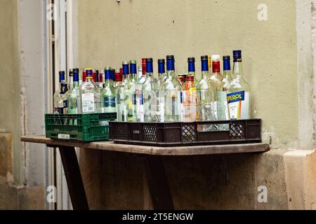 Old empty liquor bottles for recycling. Glass material from different alcoholic drinks standing around. Waste from a pub or bar after a party night. Stock Photo