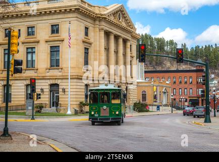 Deadwood, South Dakota, USA - March 2017. The trolly car carry tourist near the Post Office building. Stock Photo
