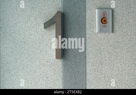 A frist floor label on the wall beside the elevator of the building. Stock Photo