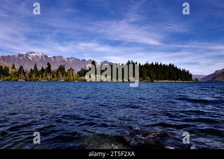 View from shore of St Omer Park on Lake Wakatipu in Queenstown New Zealand 2023. Beautiful clear day meaning you can see across the lake. Stock Photo
