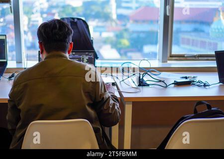 Back view of IT system developer busy working with computer system programming code Stock Photo