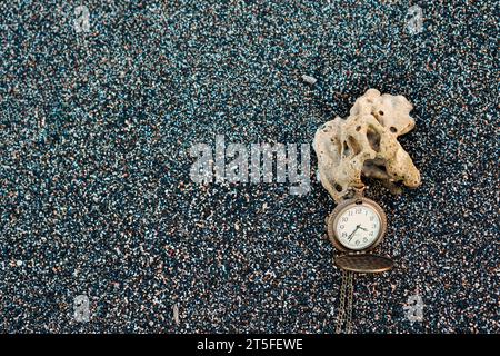 Gold color pocket watch lying on the sand. With copy space for text Stock Photo