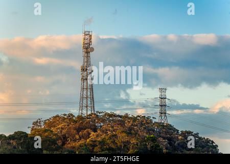 Mobile tower and power lines installation, cell site and telecom base station. 5G internet online generation. Health hazards caused by mobile tower Stock Photo