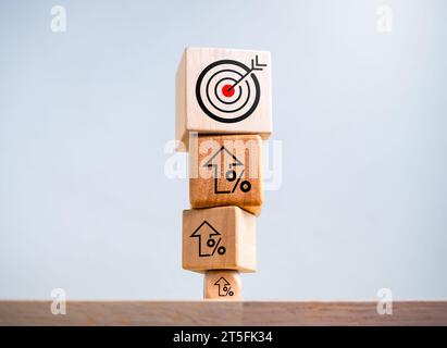 Big target icon on the top of increase arrow percentage symbol on wooden cube blocks stack isolated on white background. Investment, goal and success, Stock Photo