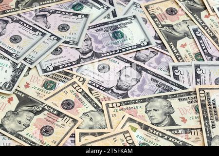 Various US dollar notes scattered. No complete notes shown and angled shot. Focus on central banknote. Stock Photo