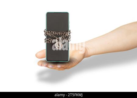 A woman's hand holds a mobile phone on a chain with a padlock on a white background, data protection and security from theft, technology Stock Photo
