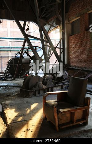 abandoned mechanical equipment and old sofa in a factory Stock Photo