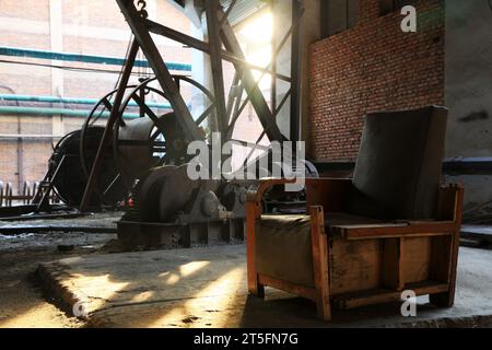 abandoned mechanical equipment and old sofa in a factory Stock Photo