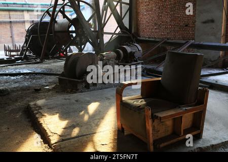 abandoned mechanical equipment and old sofa in a factory Stock Photo