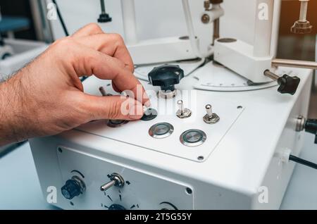 Man's hand holds handle of device. Modern ophthalmological device. Stock Photo