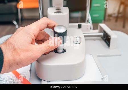 Modern ophthalmological device. Man's hand holds handle of device. Stock Photo
