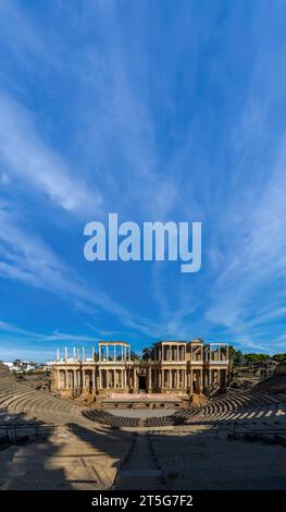 Panoramic view of the stage and stands of the Roman Theater of Mérida, illuminated by the light of dawn creating shadows on the stands under a large c Stock Photo