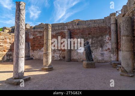 Ruins of a Roman hall with columns and the bronze statue of the actress Margarita Xirgu from the Roman Theater of Mérida. Stock Photo
