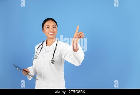 Asian Doctor Woman Using Invisible Touchscreen, Pressing Key With Finger Stock Photo