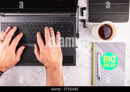 man typing on a laptop, flatlay image Stock Photo