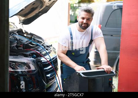 Cheerful auto mechanic checking customer vehicle AC Stock Photo
