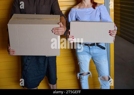 Woman with neat manicure and man are standing near yellow container Stock Photo