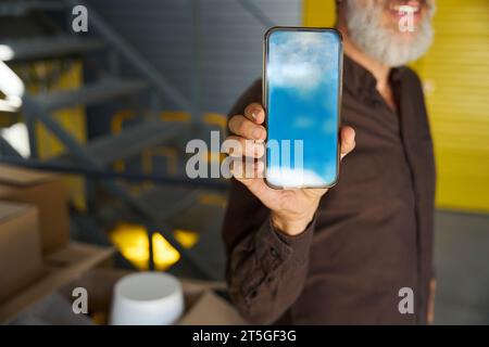 Bearded man holds a mobile phone in his hand Stock Photo