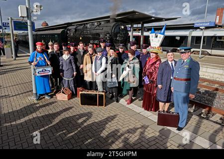 Blankenburg, Germany. 05th Nov, 2023. Participants in a special trip by an old steam locomotive stand in historical uniforms at Halberstadt station. The special trip of steam locomotive 95 027 took place on the 100th anniversary of the steam locomotive. The Rübelandbahn working group had the historic steam locomotive run from Blankenburg to Halberstadt over two days. Credit: Matthias Bein/dpa/Alamy Live News Stock Photo