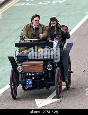 Brighton  UK 5th November 2023 -  Participants in an 1898 Rochet-Schneider wave to the crowds on Brighton seafront during this years RM Sotheby's London to Brighton Veteran Car Run commemorating the famous Emancipation Run of November 1896.  : Credit Simon Dack / Alamy Live News Stock Photo