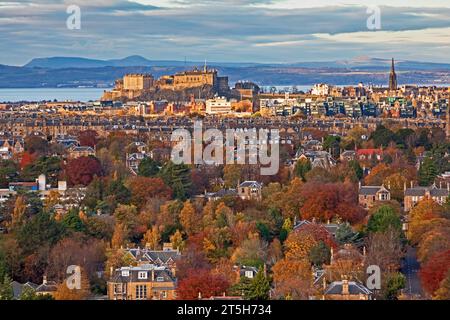 Edinburgh, Scotland, UK. 5th November 2023. View from Blackford Hill over The Grange, Marchmont to Edinburgh Castle and the Fife coast beyond, the colourful foliage is nature's fireworks display with the sparkling vibrant colours of the decidous trees and shrubbery. Temperature 9 degrees centigrade with cloudy sunshine. Stock Photo