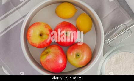 Apples and lemons close-up on a kitchen table. Fruit cake recipe, ingredients close-up Stock Photo