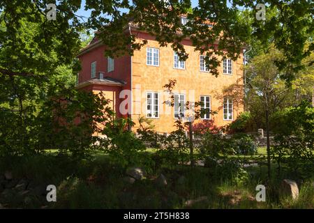 TINGSRYD, SWEDEN ON MAY 16, 2018. View of a building partly hidden behind vegetation. Garden and fence this side. Editorial use. Stock Photo