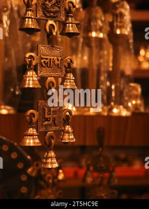 old,souvenir hanging brass bells with religious symbols from an antique indian gift shop Stock Photo