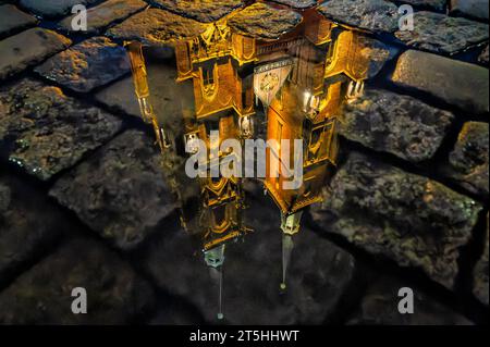 Reflection of the towers of the Wroclaw Cathedral in a puddle, on the cobblestones of the street. Silesia, Poland Stock Photo