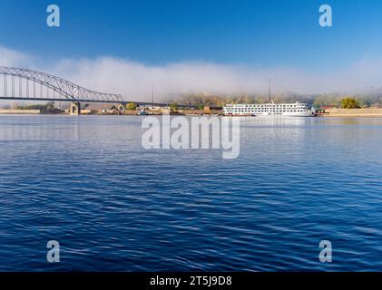 Upper Mississippi on calm misty morning at Dubuque with docked river cruise boat by Julien Dubuque Bridge Stock Photo