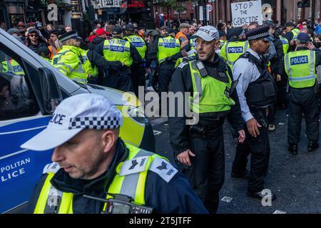 London, UK. 4th November, 2023. Metropolitan Police officers escort a police vehicle through a crowd of pro-Palestinian protesters from the Free Palestine Coalition during a march through central London to call for an immediate ceasefire in Gaza. Mass Palestinian solidarity rallies have been held throughout the UK for a fourth consecutive weekend to call for an end to the Israeli bombardment of Gaza. Credit: Mark Kerrison/Alamy Live News Stock Photo