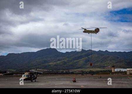 A Hawaii Army National Guard CH-47 Chinook conducts aerial fire suppression water drop operations in response to the Mililani wildfires at Mililani, Hawaii, Nov. 4, 2023. The Hawaii National Guard supports the city and county of Honolulu and the Honolulu Fire Department in firefighting efforts on the island of Oahu, Hawaii.  (U.S. Army National Guard photo by Sgt. Lianne M. Hirano) Stock Photo