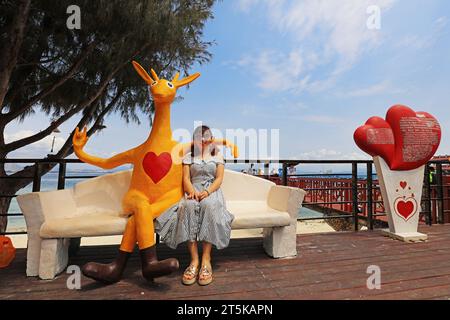 Sanya City, Hainan - March 31, 2019: Tourists rest beside kangaroo sculptures，Sanya City, Hainan Province, China Stock Photo