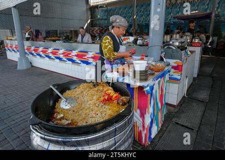 Tashkent, Uzbekistan - October 29, 2023: A woman cooking rice at Chorsu Bazaar in Tashkent, Uzbekistan. Stock Photo