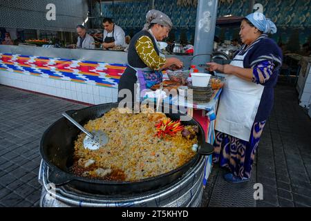 Tashkent, Uzbekistan - October 29, 2023: Two women cooking rice at Chorsu Bazaar in Tashkent, Uzbekistan. Stock Photo