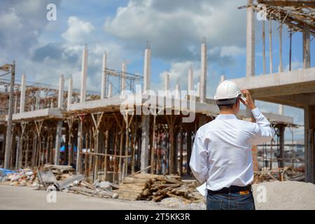 Engineer working and checking plan on construction site. Stock Photo