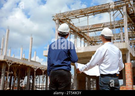 Two engineer working and checking plan on construction site. Stock Photo