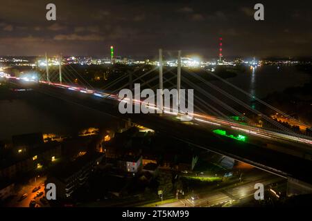 Duisburg, Germany. 06th Nov, 2023. Vehicles drive over the new Rhine bridge on Monday morning with the lights switched on, in front of the old Rhine bridge, which is no longer in operation. The closure of the Rhine bridge on the A40 in Duisburg comes to an end. The newly built Rhine bridge is now in operation. The old bridge is no longer safe to drive on after the truck weighing systems were dismantled. Credit: Christoph Reichwein/dpa/Ģ����ý Live News Stock Photo