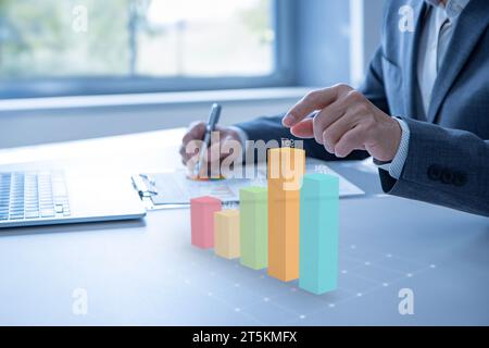 Colorful augmented reality bar graph floating above the desktop surface showing business performance or financial information for investment Stock Photo