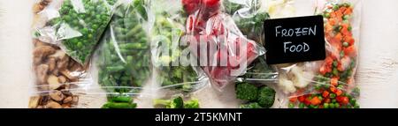 Set of different frozen vegetables in plastic bags on white background. Top view. Panorama. Stock Photo