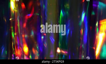 A diamond sparkling with different rainbow neon colors on a dark background. Prism Light Flares Overlay on Black Background Stock Photo