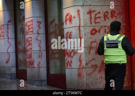 A security guard stands and looks at the pro-Palestinian graffiti on the exterior of the building. Activists from Palestine Action occupy and target Italian arms industry giant Leonardo at their London headquarters and shut them down. Leonardo supply Israel with fighter jets and weaponry that are currently being used in Gaza. Palestine Action demands that arms companies providing weapons for Israel shut down permanently. They have announced that companies selling weapons to the Israeli Defence Force and their partner companies will be targeted with direct action. These actions are intended to Stock Photo