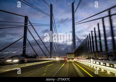 Duisburg, Germany. 06th Nov, 2023. Vehicles drive over the new Rhine bridge on Monday morning with the lights switched on, on the left the old Rhine bridge, which is no longer in operation. Closure of the Rhine bridge on the A40 in Duisburg comes to an end. The newly built Rhine bridge is now in operation. The old bridge is no longer safe to drive on after the truck weighing systems were dismantled. Credit: Christoph Reichwein/dpa/Ģ����ý Live News Stock Photo