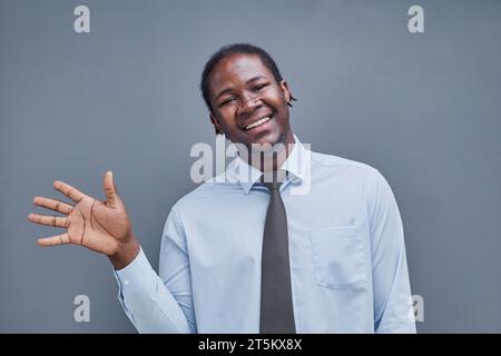 young african american man on gray background high fiving Stock Photo