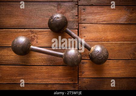 Old rusty dumbbells on rustic wood board background texture Stock Photo